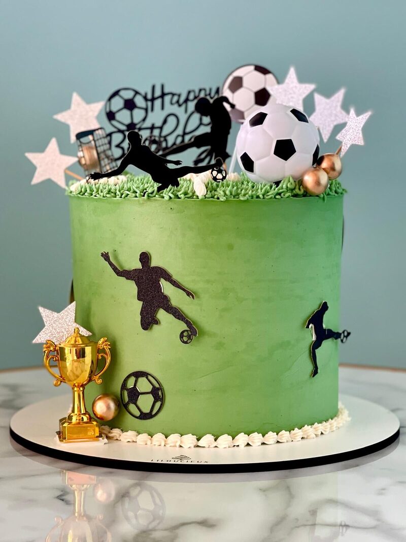 Gâteau d'anniversaire sur le thème du football, crème verte, ballons et trophée