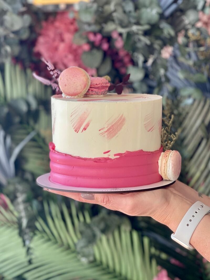 Gâteau crème et rose pastel décoré de macarons