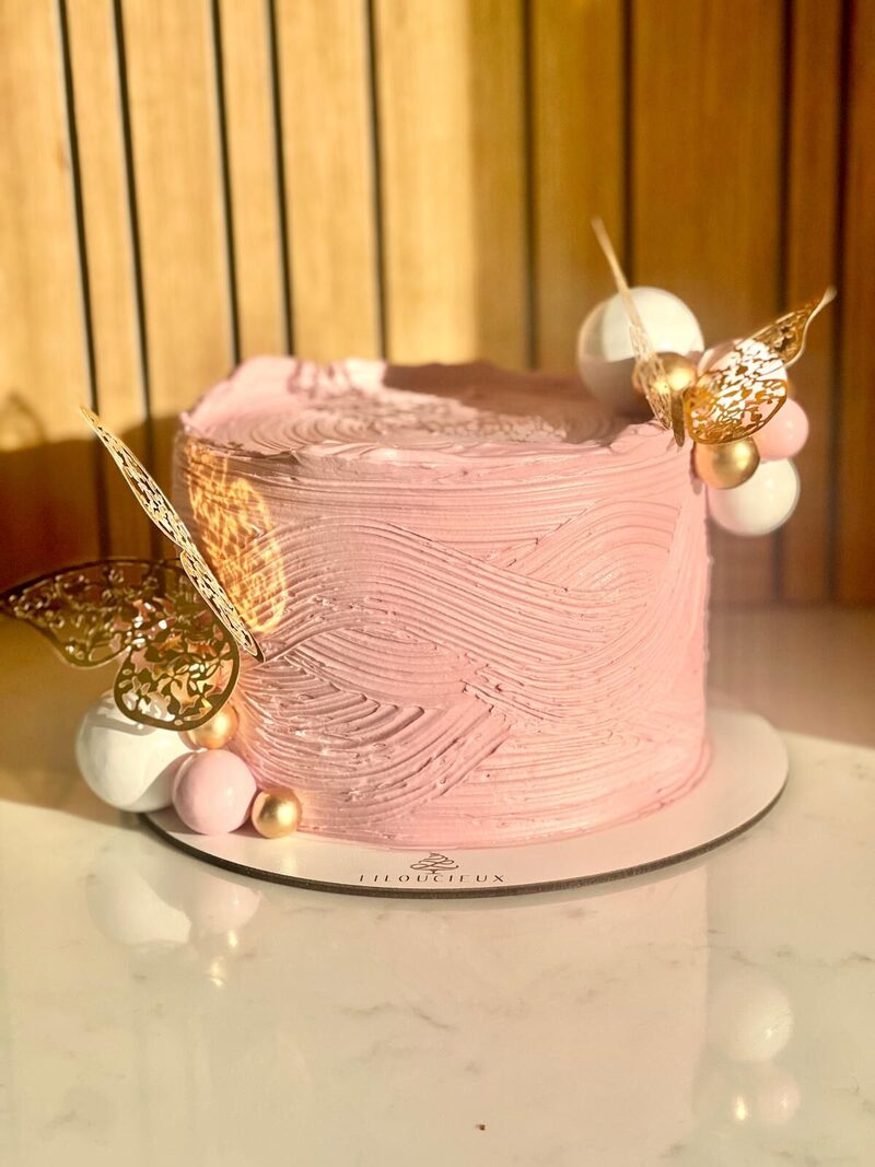 Gâteau rose texturé au papillon doré
